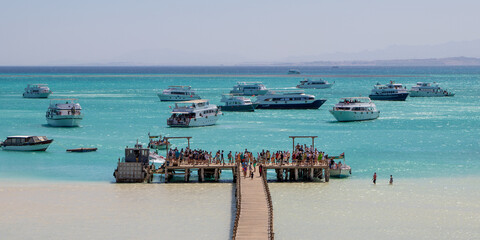 Hurghada, Egypt - September 23 2021: Wooden Pier at Orange Bay Beach with crystal clear azure water...