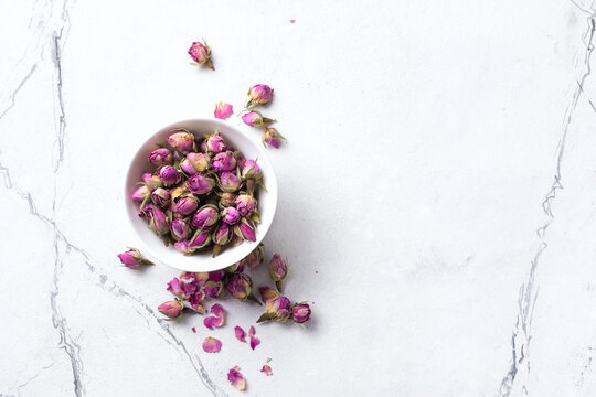 White bowl with dried rose buds for tea