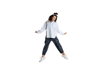 Studio shot of young woman in casual wear jumping, flying isolated on white background. Art, motion, action, flexibility, inspiration concept. - obrazy, fototapety, plakaty