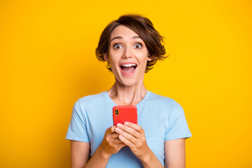 Photo of young excited girl happy positive smile amazed surprised use cellphone chat isolated over...