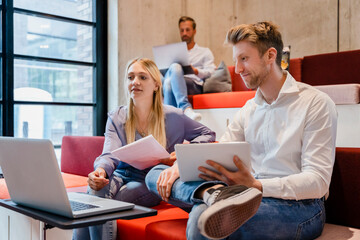 Young coworkers using laptop at desk