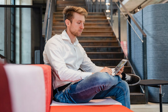 Young Businessman Using Tablet PC At Workplace