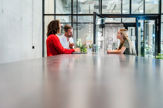 Recruiters having discussion with candidate at conference table