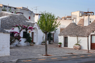white traditional southern italian trulli village houses with tapered stone roofs