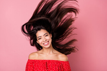 Portrait of attractive cheerful brunet girl having fun wind blowing long hair isolated over pink pastel color background