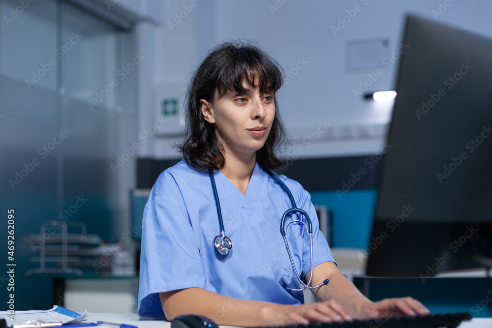 Poster healthcare specialist working with monitor and keyboard in doctors office. medical assistant using c