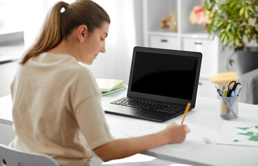 Fototapeta premium education, online school and distant learning concept - student woman with laptop computer drawing picture at home