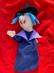 Top view of a puppet toy on a red blanket.