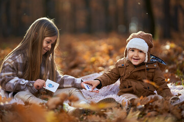 Brothers playing cards in the forest, autumn time