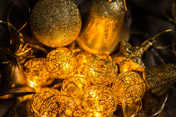 Golden garland and Christmas toys on a dark background. Christmas decorations. Glowing garland