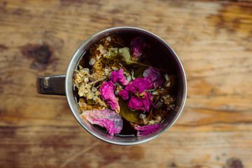 Touristic mug with herbal tea on the rustic background. Selective focus.