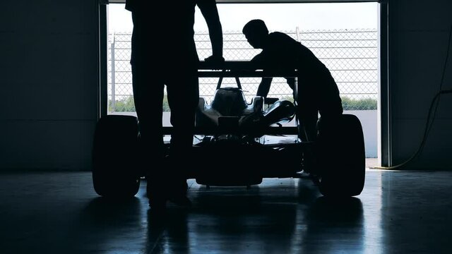 Racing car is getting wheeled into the workshop