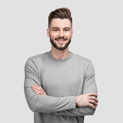 Portrait of handsome smiling young man with folded arms. Smiling joyful cheerful men with crossed hands isolated studio shot.