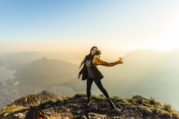 Young man dancing with scarf on mountain peak at Orobie Alps, Lecco, Italy
