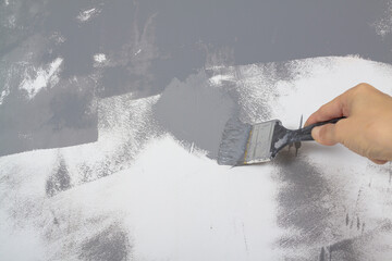 Paint a white wall with a brush in gray