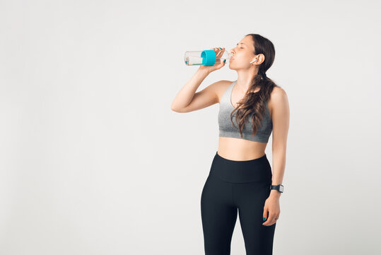 Photo of young woman hydrating over white wall.