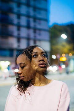 Double exposure of young woman with braided hair in city