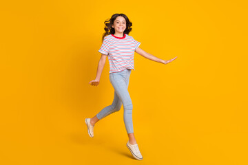 Fototapeta na wymiar Full size profile side photo of young schoolgirl happy positive smile go walk step jump isolated over yellow color background