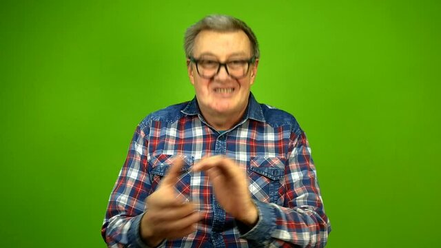 Mature adult strange man in stupid glasses is emotionally claps his hands.