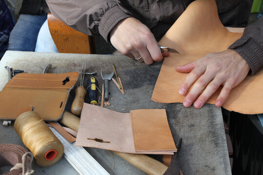 Handmade leather goods, craftsman at work in a workshop.