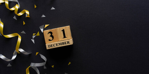 close up number 31 December cube shape wood with gold and silver color of rolling ribbon and...