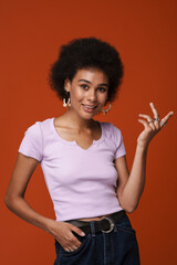 Black young woman in earrings gesturing and smiling at camera