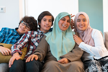 Middle eastern family portrait single mother with teenage kids at home in living room. Selective focus 