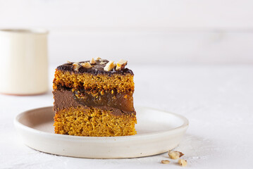 A piece of chocolate pumpkin pie with nuts on a plate. Sugar, gluten and lactose free, vegan. Horizontal orientation, copy space.