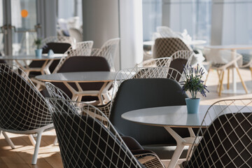 An empty cafeteria interior shot. Large windows letting in light.