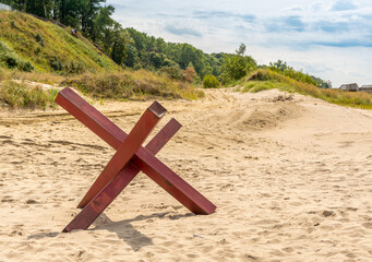 Steel anti-tank hedgehog standing on the beach. © YuNIK
