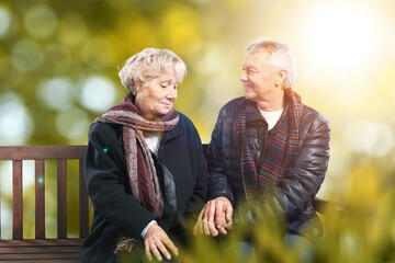 Senior couple in the park wearing winter clothing walking