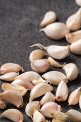 Fresh garlic cloves on black table background.