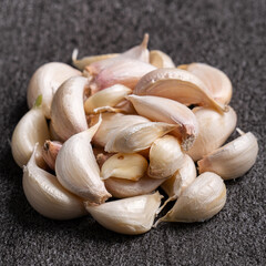 Fresh garlic cloves on black table background.