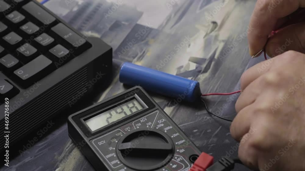 Poster checking the battery voltage with a multimeter