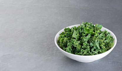 Bowl with kale leaves on gray background. With clipping path.