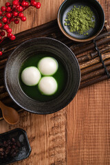 Matcha big tangyuan and matcha soup on wooden table.