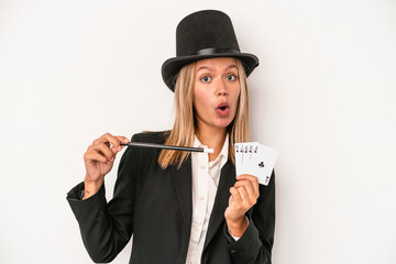 Young caucasian wizard woman holding wand and magic cards isolated on white background