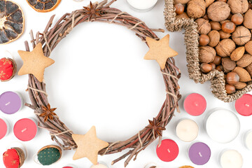 Detail top studio shot of handmade, dry Christmas wreath with gingerbread stars and star anises isolated on white background. Christmas concept. Traditional hand work. Candles, nuts and dried fruits.