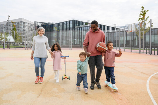 Smiling Family Walking Together On Sports Field