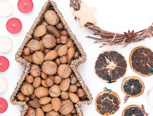 Detail top studio shot of handmade, dry Christmas wreath with gingerbread stars and star anises isolated on white background. Christmas concept. Traditional hand work. Candles, nuts and dried fruits.