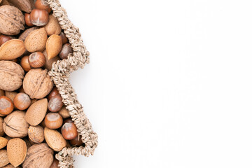 Top detail studio shot of basket full of mixed nuts isolated on white background with lot of free space to the right. Christmas concept.