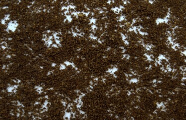Ground coffee is scattered on a white table
