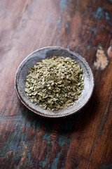 Dry yerba mate leaves on wooden background. Close up.  