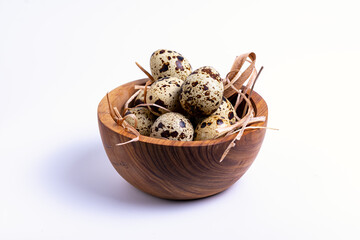 isolate, wooden bowl with quail eggs on a white background, close-up
