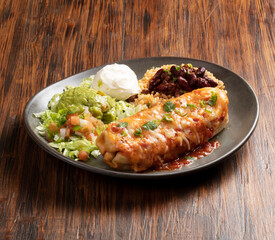 Burrito mexicano con jamon, queso y vegetales sobre madera. Mexican burrito with ham, cheese and vegetables on wood
