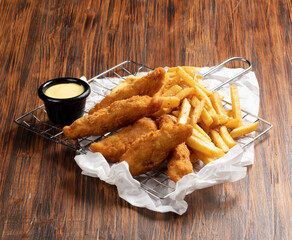 Nuggets de pollo con salsa de mostaza sobre mesa de madera. Chicken nuggets with mustard sauce on wooden table