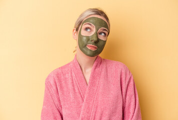 Young caucasian woman wearing face mask isolated on yellow background dreaming of achieving goals and purposes