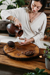 Cacao ceremony in atmospheric space with green plants and candles. Woman making ritual healthy...
