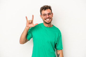 Fototapeta premium Young caucasian man isolated on white background showing a horns gesture as a revolution concept.