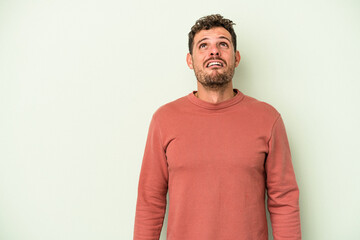 Fototapeta premium Young caucasian man isolated on green background shouting very angry, rage concept, frustrated.